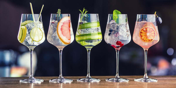 Five Elephant Gin & Snow Leopard Vodka drink mixes in wine glasses lined up with various garnishing colours.